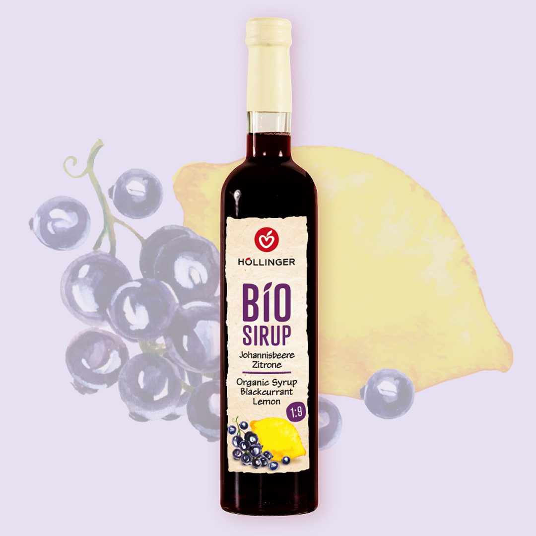 Höllinger Bio Sirup Johannisbeere Zitrone in Glasflasche vor einem Hintergrund mit Johannisbeeren und einer Zitrone